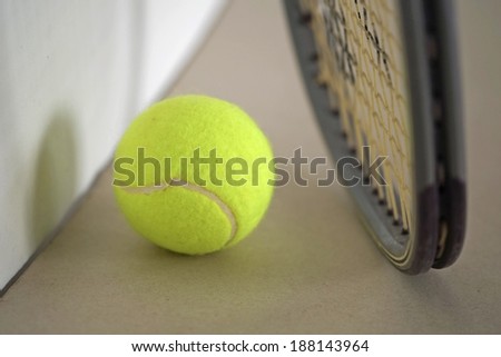 Tennis ball with racket on the ground.