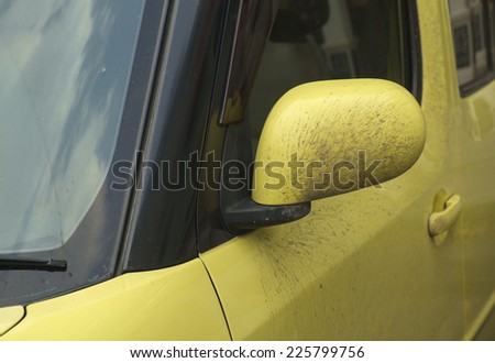 Dirty yellow mirror of car.