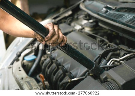 Cleaning car engine by using vacuum cleaner.