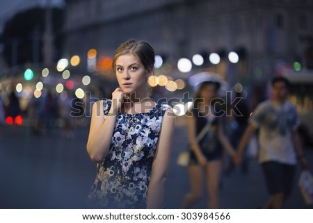 Beautiful young girl under the lights of the night city, beautiful bokeh, light lamps and vehicles, unique picture of the night city.