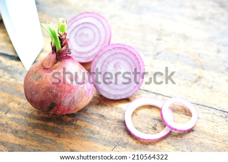 red onions and onions rings on wooden table.