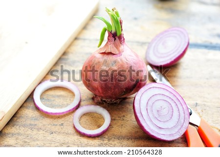 red onions and onions rings on wooden table.