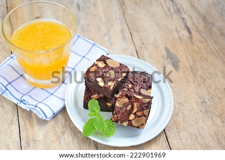 Cake chocolate brownies with nuts orange juice.