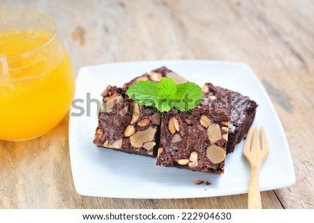 Chocolate brownie with nuts and fresh orange juice.