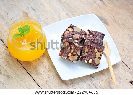 Chocolate brownie with nuts and fresh orange juice.