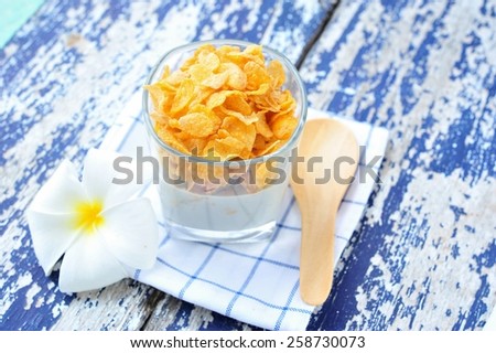 Cornflakes with milk in glass on vintage table.