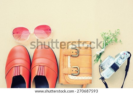 Vintage leather shoes ,leather wallet,fashion eye wear and camera on wood background.