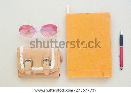 Leather bag,note book,pen and eye wear on wood background.