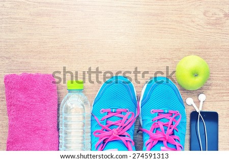 Sport shoes and water with set for sports activities on tiled floor.