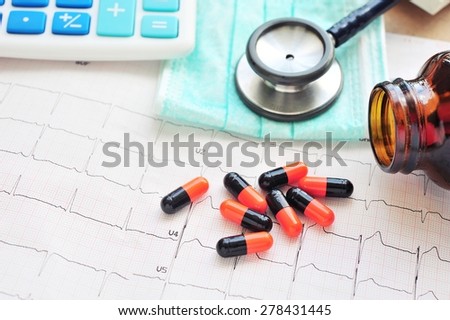Medicine,Stethoscope and calculator on electrocardiogram paper.Health care costs.