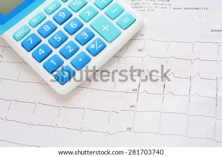 Calculator on cardiogram chart.Health care costs.