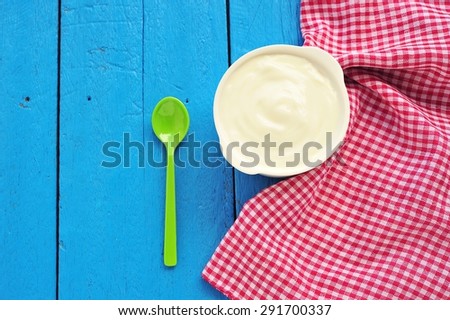 Yogurt on blue paint wooden floor with copy space.