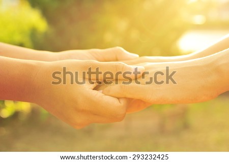 Soft focus photo, couple holding hands in the sunset.