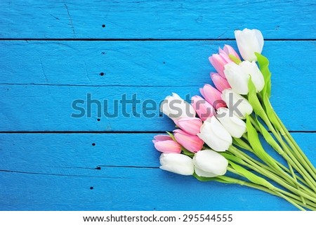 bouquet of colorful tulips on blue paint  wooden floor.