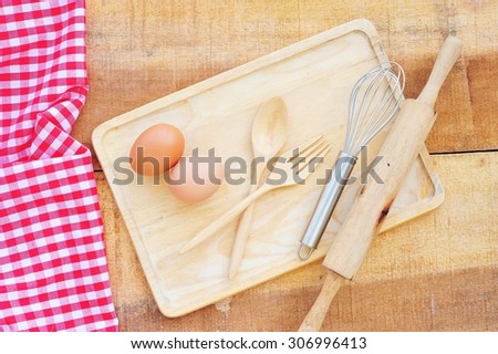 Baking ingredients and tools on wooden tray.