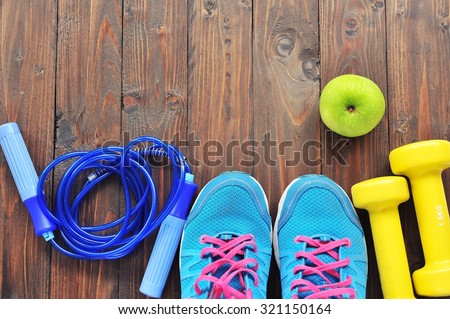 Shoes and sports equipment on wooden floor.