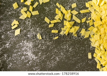 Grandmother\'s home made pasta on black surface, yellow black background