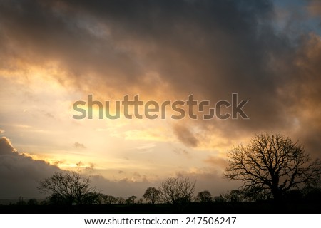 Stormy clouds as the sun sets over the countryside