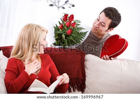 Fun Valentine's Day Holiday series with young Caucasian couple sitting around exchanging gifts.