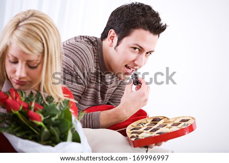 Fun Valentine\'s Day Holiday series with young Caucasian couple sitting around exchanging gifts.