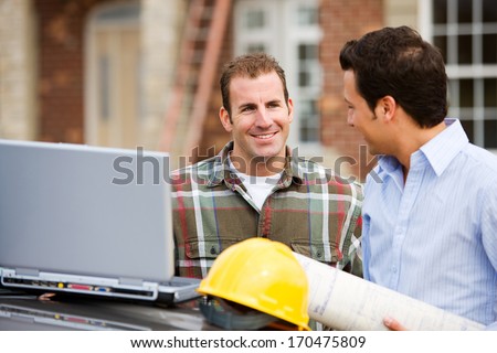 Construction: Architect And Builder Look At Laptop.