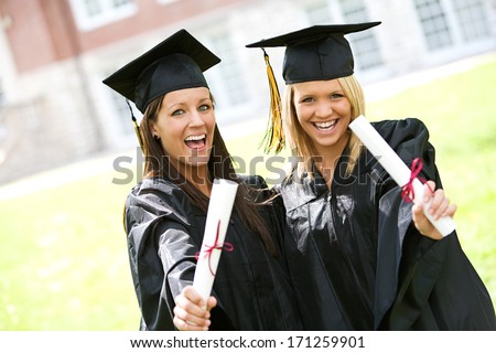 Graduation: Proud Female Graduates Hold Out Diplomas