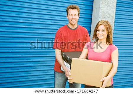 Storage: Couple Carrying Boxes To Storage Unit