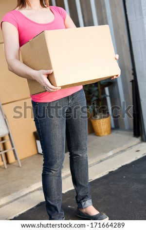 Storage: Storage: Anonymous Woman Holding Box By Storage Unit