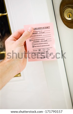 Delivery: Man Puts Notification Paper On Front Door