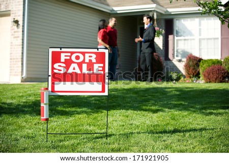 Real Estate: For Sale Sign With Agent And Home Buyer Behind