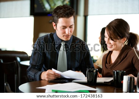 Coffee Shop: Co-Workers Look Over Documents