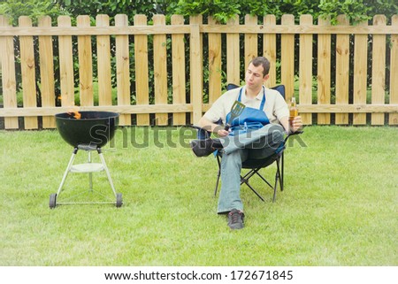 Grilling: Man In Backyard Sitting By Grill