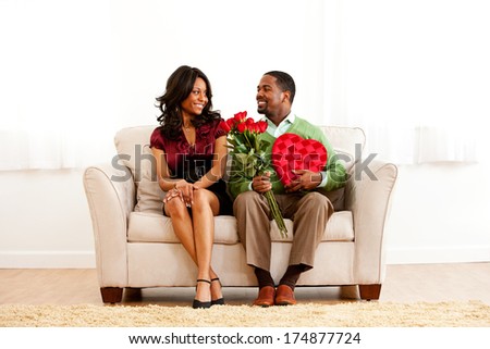 Valentine: Romantic Couple On Couch with Candy and Flowers