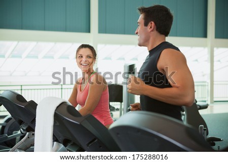 Gym: Friends Talk While Jogging On Treadmills