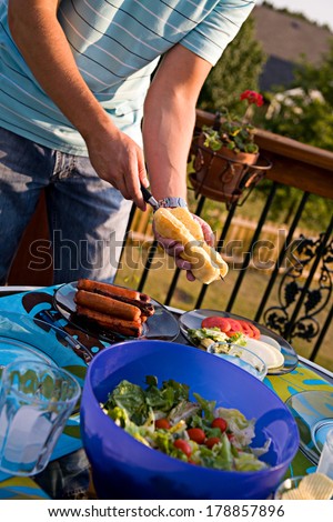 Family: Man Cutting Hot Dog Bun with Knife