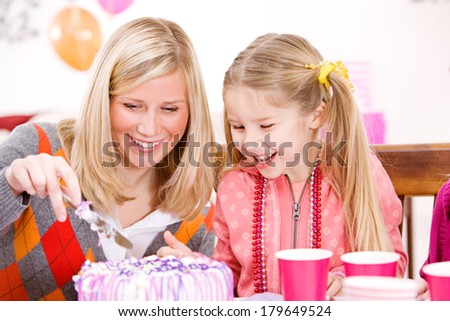 Birthday: Mother Cuts Cake For Girl