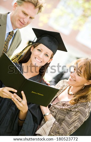 Graduation: Smiling Student With Parents and Diploma