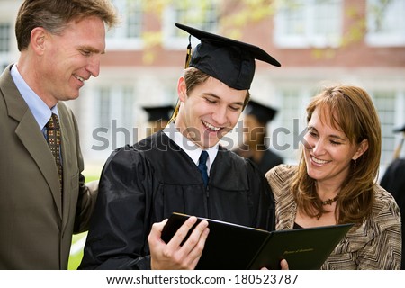 Graduation Male Student Stands Proudly With Parents Graduation Male Student Stands Proudly With Parents