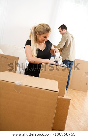 Moving: Woman Using Packing Tape On Boxes