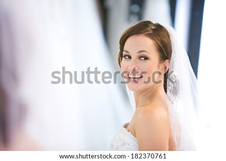 Bride: Woman Looks In Mirror Of Wedding Gown Shop