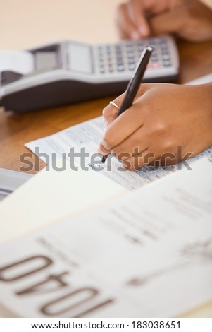 Taxes: Woman Using Pen to Fill Out Tax Forms