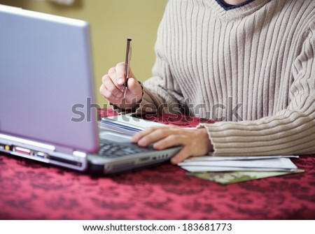 Finances: Man Writing Checks While Online