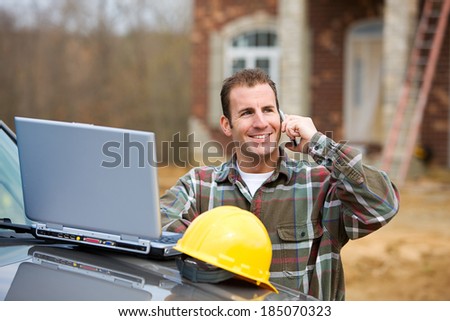 Home: Builder On Cell Phone With Laptop Computer