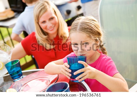 Summer: Young Girl Drinking From Glass Of Water During Dinner