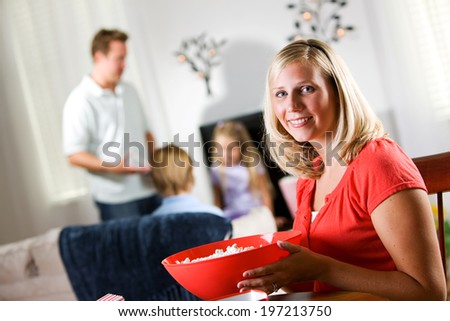 Family: Mother Holds Bowl Of Popcorn For Movie Night