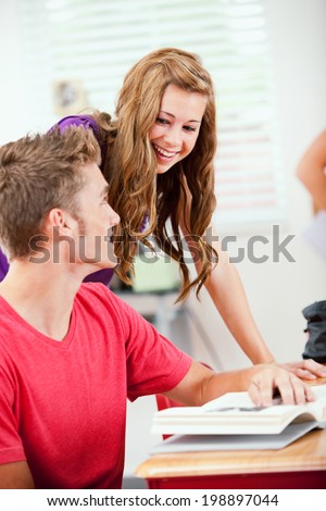 Classroom: Girl Stops By To Laugh With Male Friend At Desk