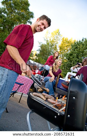 Tailgating: Guy Student Working The Grill At Tailgate Party