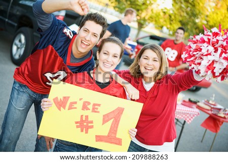 Tailgate: Three Friends Cheer And Hold Up Number One Sign