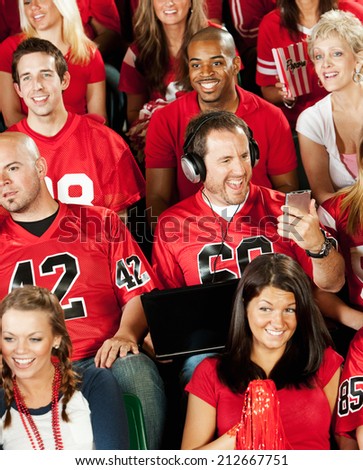 Fans: Guy At Football Game Busy Watching Electronic Device