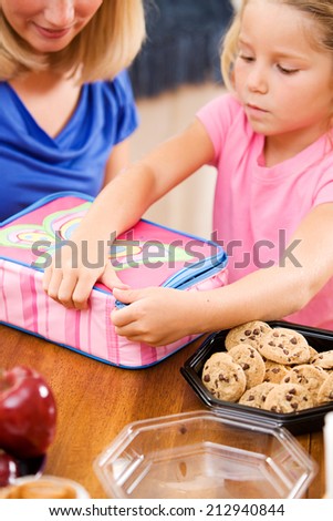 Student: Parent And Child Putting Together School Lunch